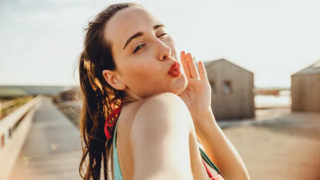 Young woman taking a selfie and blowing a kiss