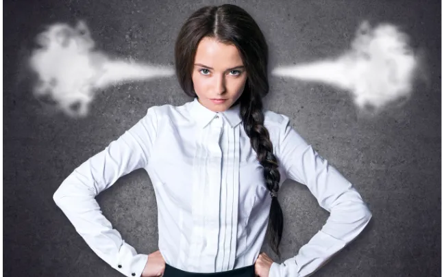 Women with braided hair and white blouse, hands at hips, steam coming from her ears