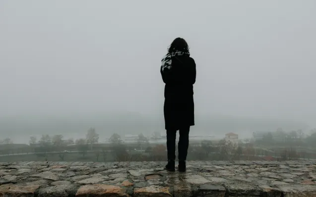 Woman standing alone in the fog