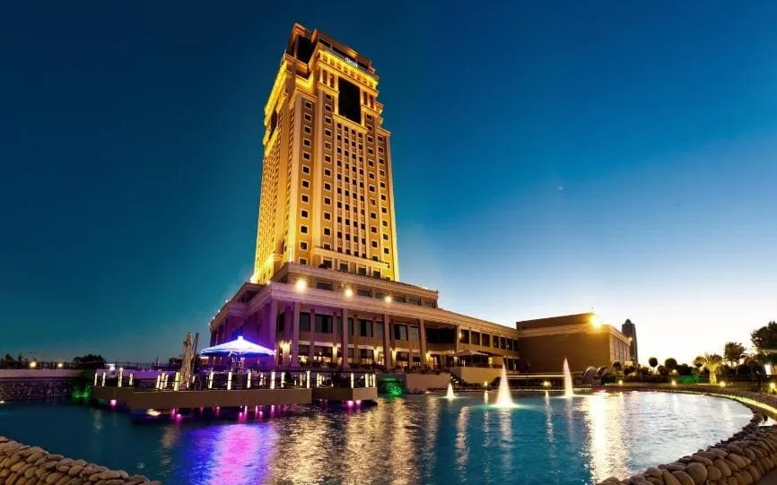 Lit up tower hotel surrounded by lake