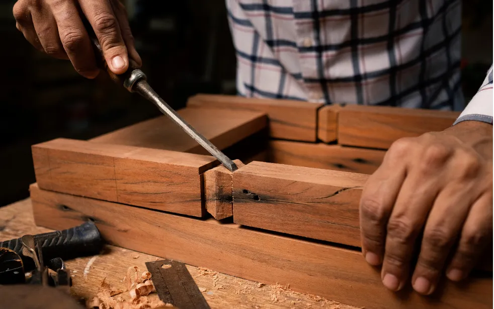 Man using chisel to shape wood